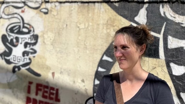 Marie-Pascale Bélanger devant un mur couvert de graffitis